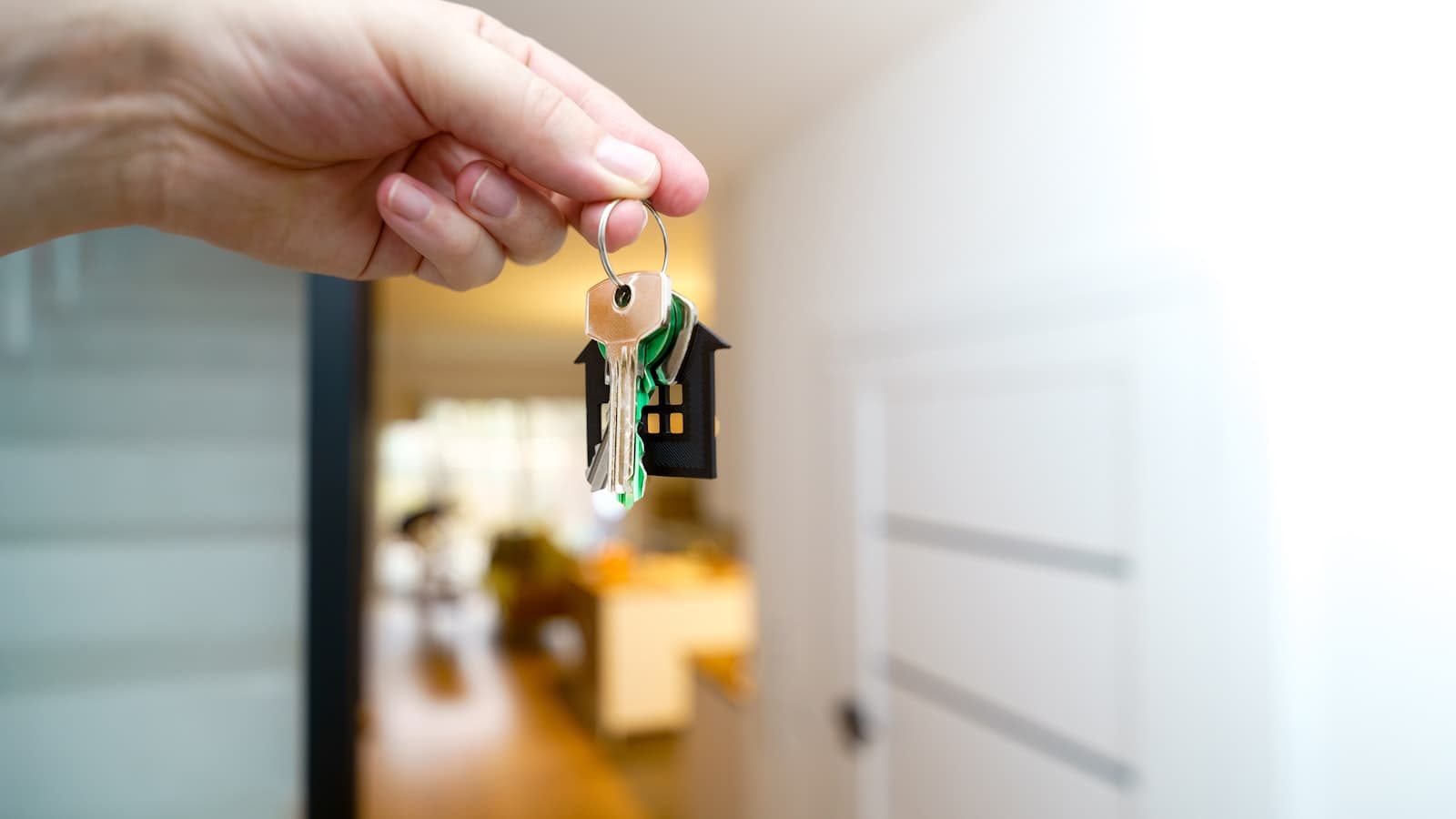 Iemand geeft huissleutels over bij de voordeur